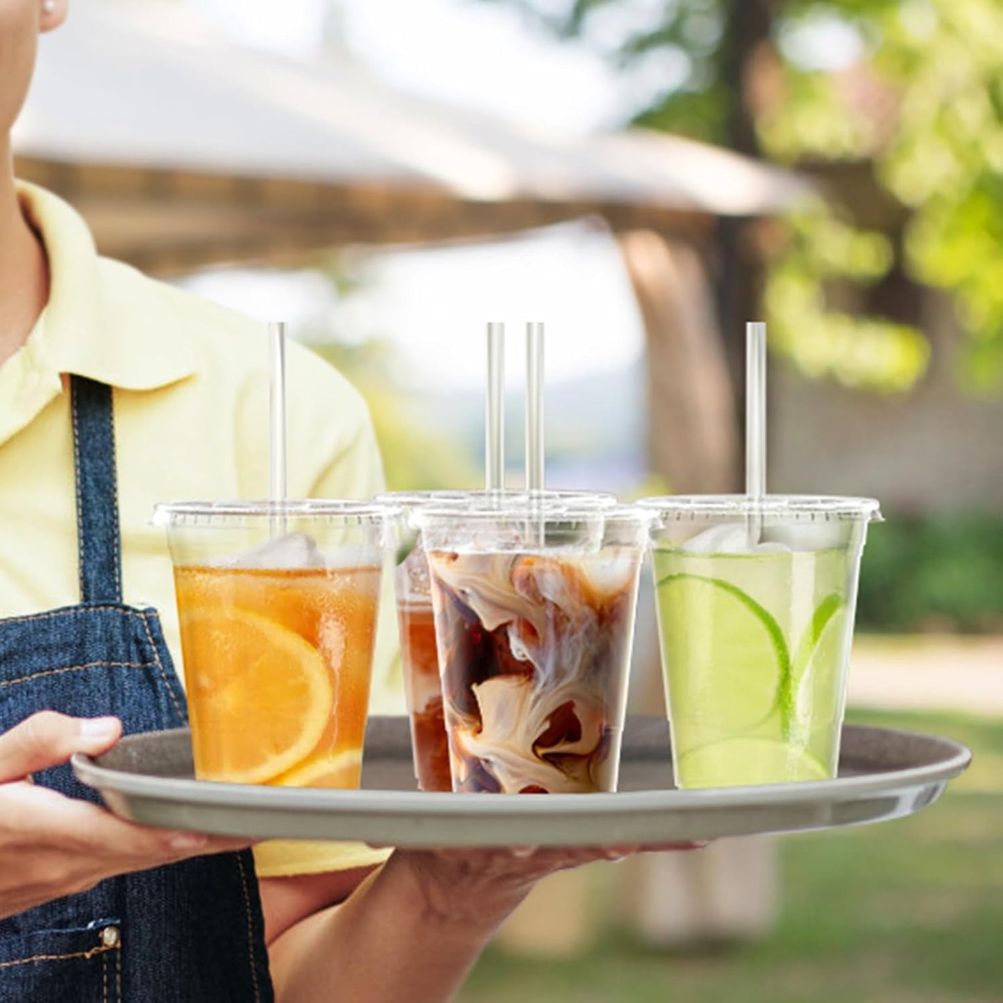 Pack of 100 - 16 oz clear plastic disposable iced coffee cups with lids.